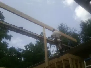Carpenter setting a ridge beam over a new addition frame — Ice Dam Removal by Roofing Brothers in Hooper