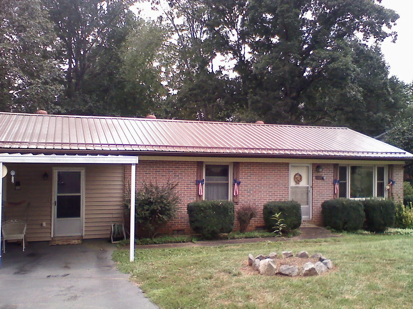 Bronze metal roof and carport on a brick ranch home — Roof Repair work by our crew in Hooper